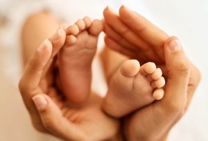 a babies feet held in parents hands